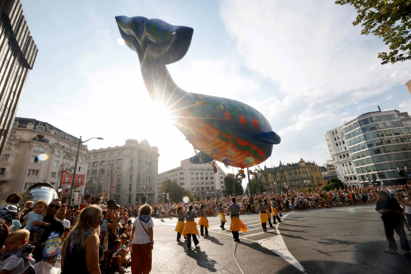La ballena Bali a contraluz sobre la Gran Vía de Bilbao, con el público a ambos lados