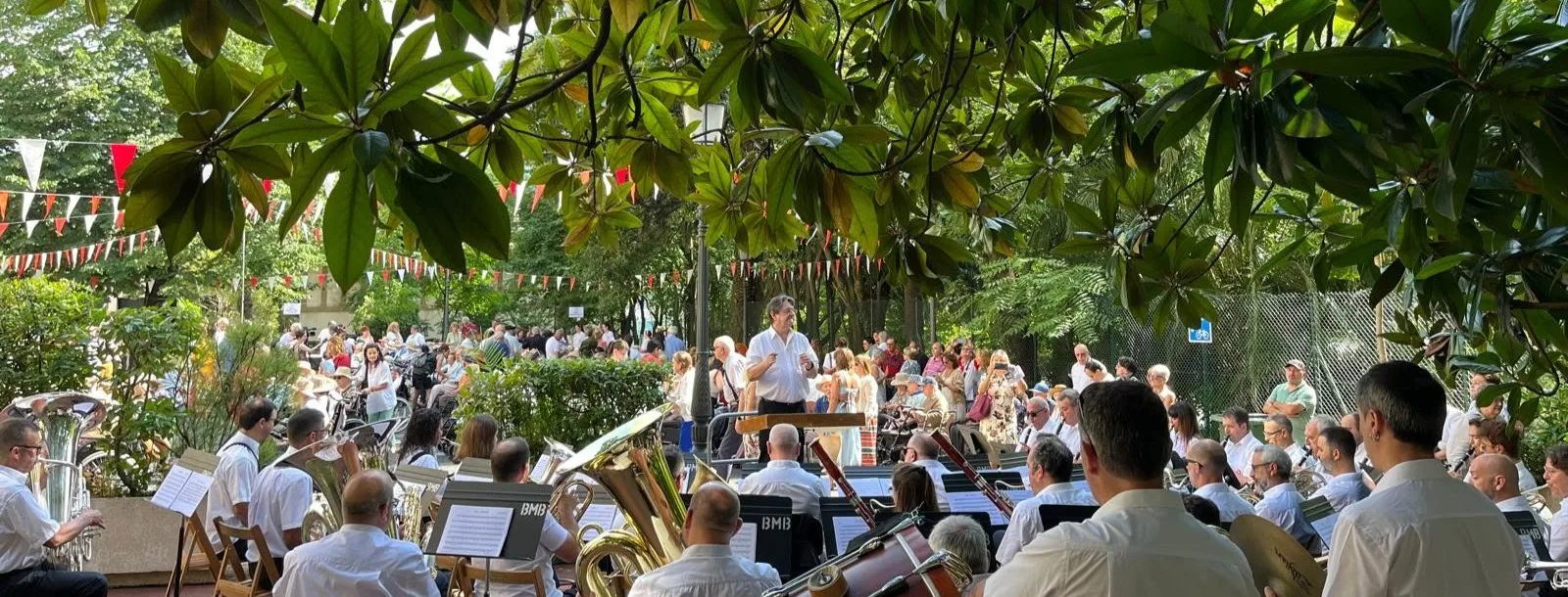 La Banda Municipal de Música toca al aire libre entre los árboles de un parque