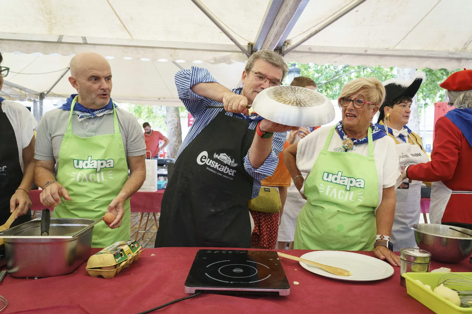 El Alcalde de Bilbao levanta un plato sobre la sartén para dar la vuelta a la tortilla