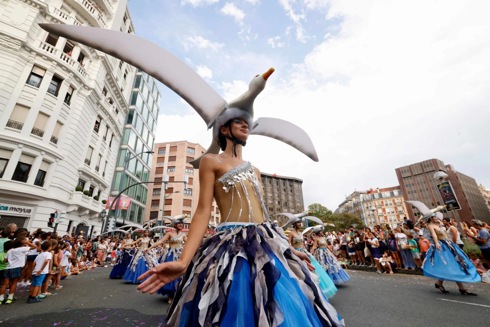 Una figura del desfile con una gaviota sobre la cabeza, sobre zancos