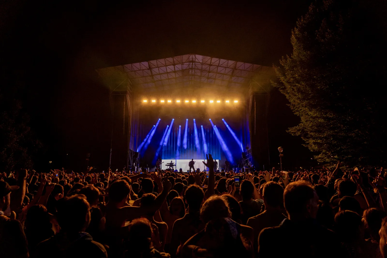 Haces de luz azul se abren desde el escenario del Parque Europa sobre un público numeroso, de noche