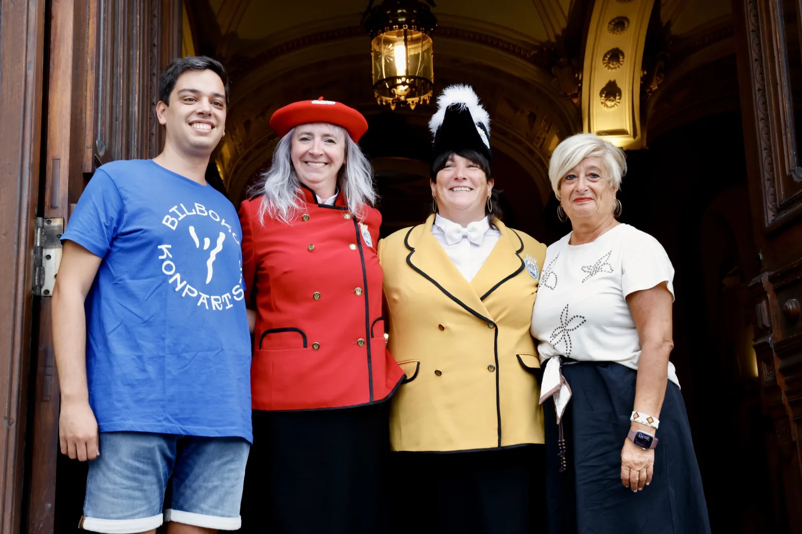 La pregonera y la txupinera de la Aste Nagusia 2026, con dos representantes de las konpartsas, en la puerta del Teatro Arriaga