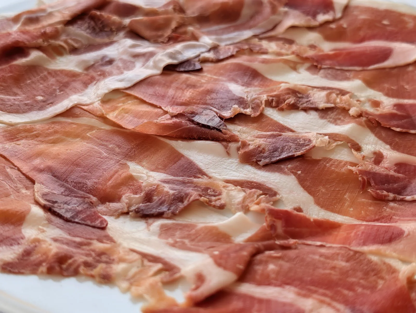 Plato de jamón ibérico de bellota extendido en lonchas finas, primer entrante del menú de Semana Grande del Asador Alaia
