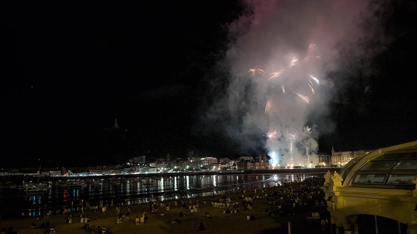 Fuegos artificiales blancos entre el humo acumulado sobre la bahía en la parte central del espectáculo