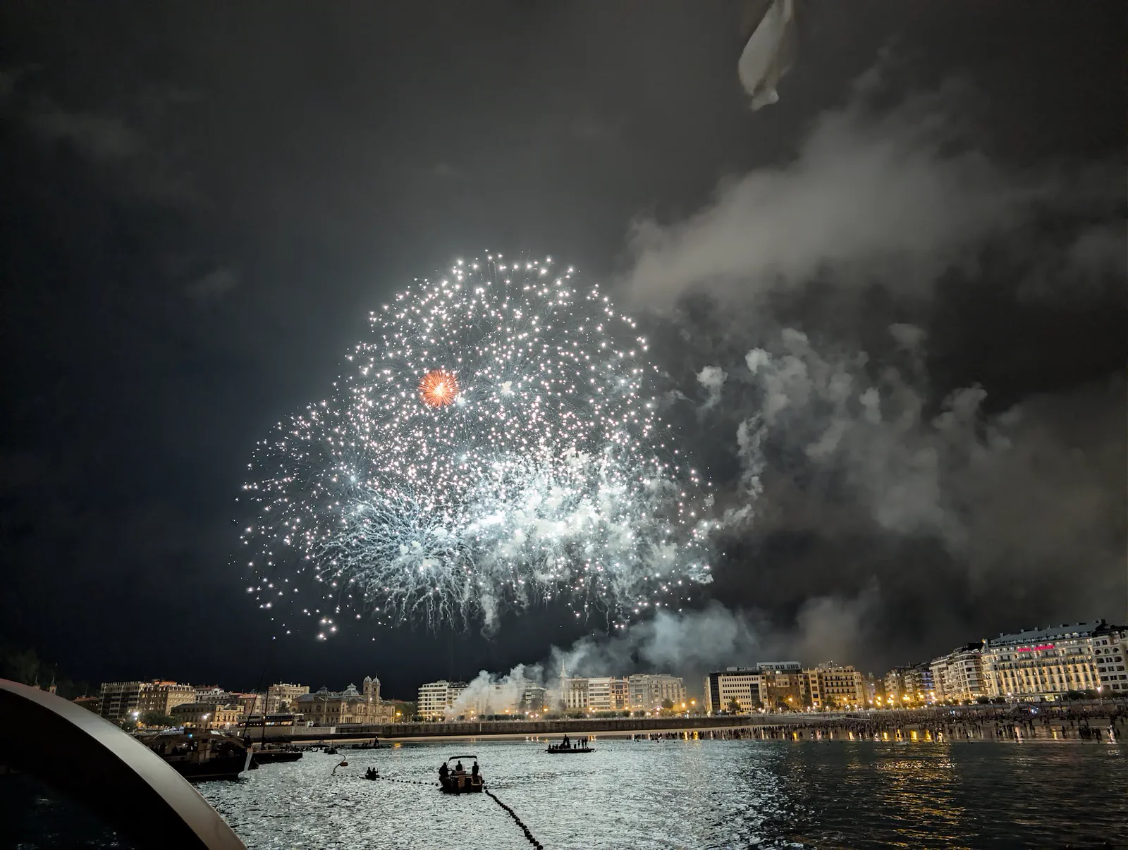 Gran flor blanca con el corazón anaranjado abriéndose sobre la bahía de la Concha