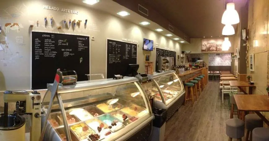 Interior de una heladería Arnoldo con el mostrador de helado artesano y el rótulo «Helado artesano» en la pared