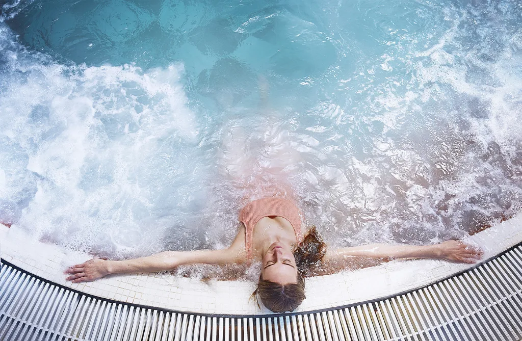Una persona relajándose en el jacuzzi de burbujas del centro de talasoterapia de La Perla