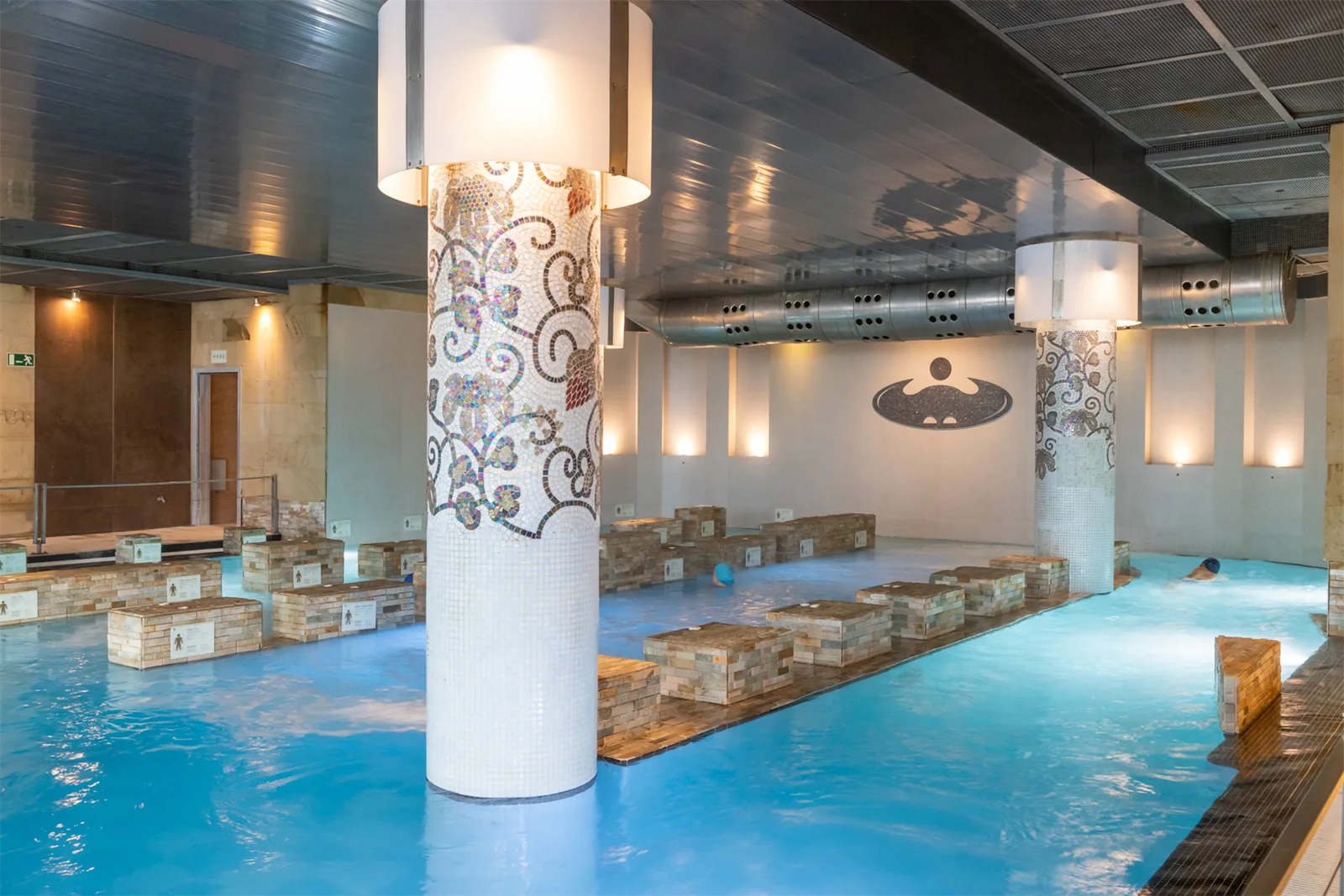 Piscina de agua de mar del talaso de La Perla, con columnas decoradas con mosaico y camas de burbujas a ambos lados