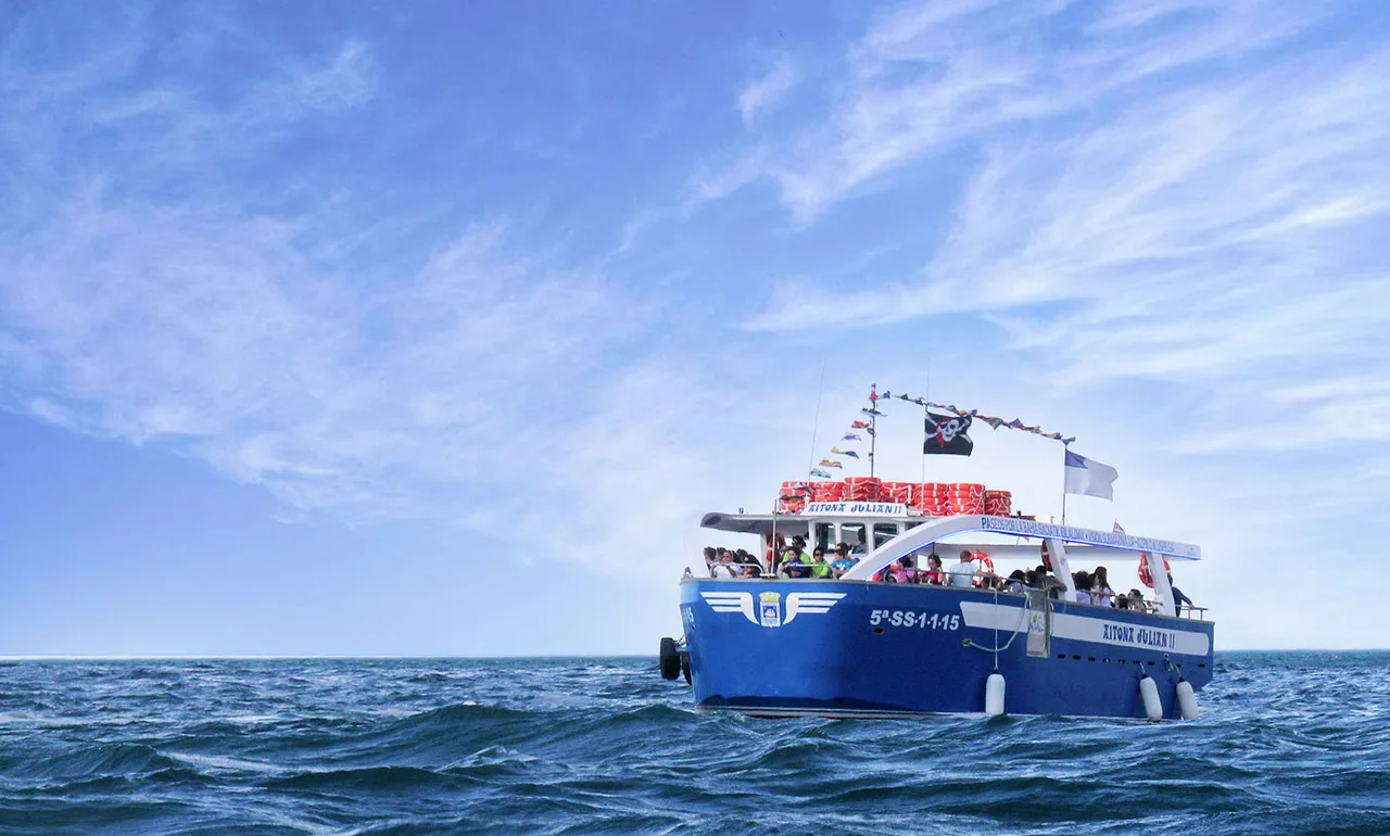 Barco de Motoras de la Isla lleno de pasajeros navegando por la bahía de la Concha de Donostia